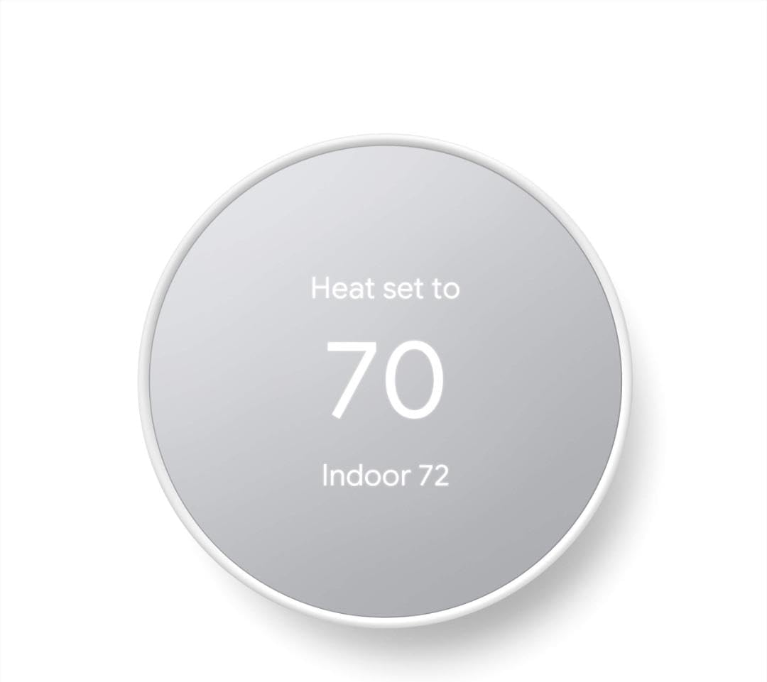 Google Nest Thermostat in Snow white with round mirrored display showing Heat set to 70 and Indoor 72 on a white wall