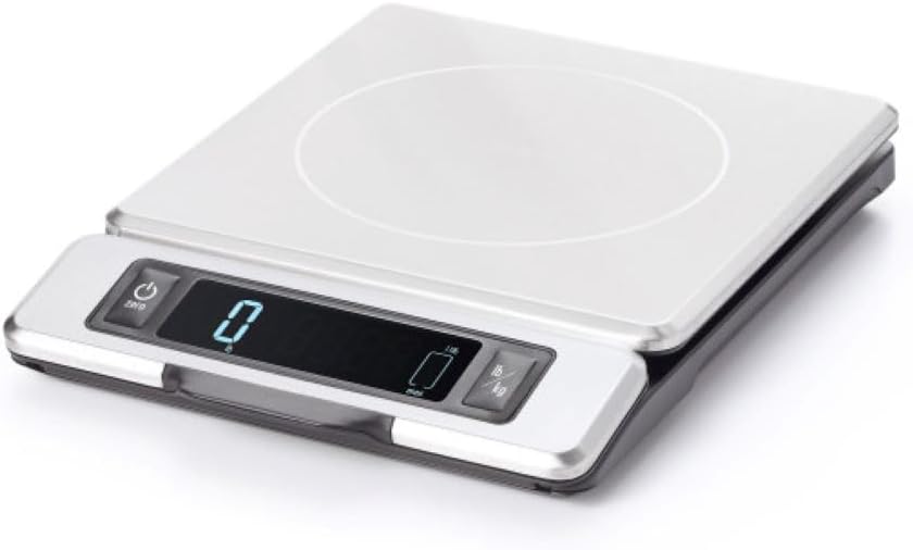 The OXO 11 lb Stainless Steel Food Scale in silver, its pull-out display retracted into the base and the stainless weighing platform on top